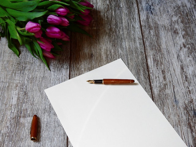 Un stylo plume posé sur une feuille de papier blanche